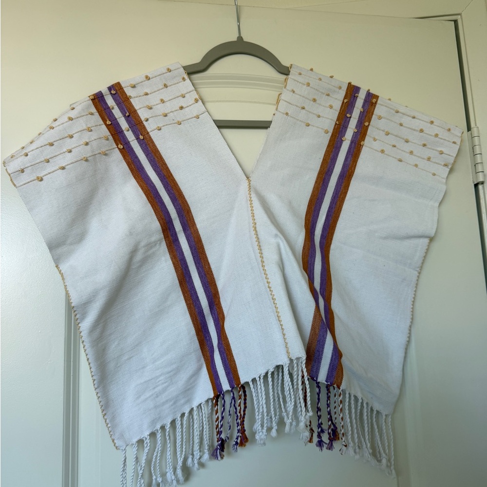 White woven poncho with purple and rust stripes